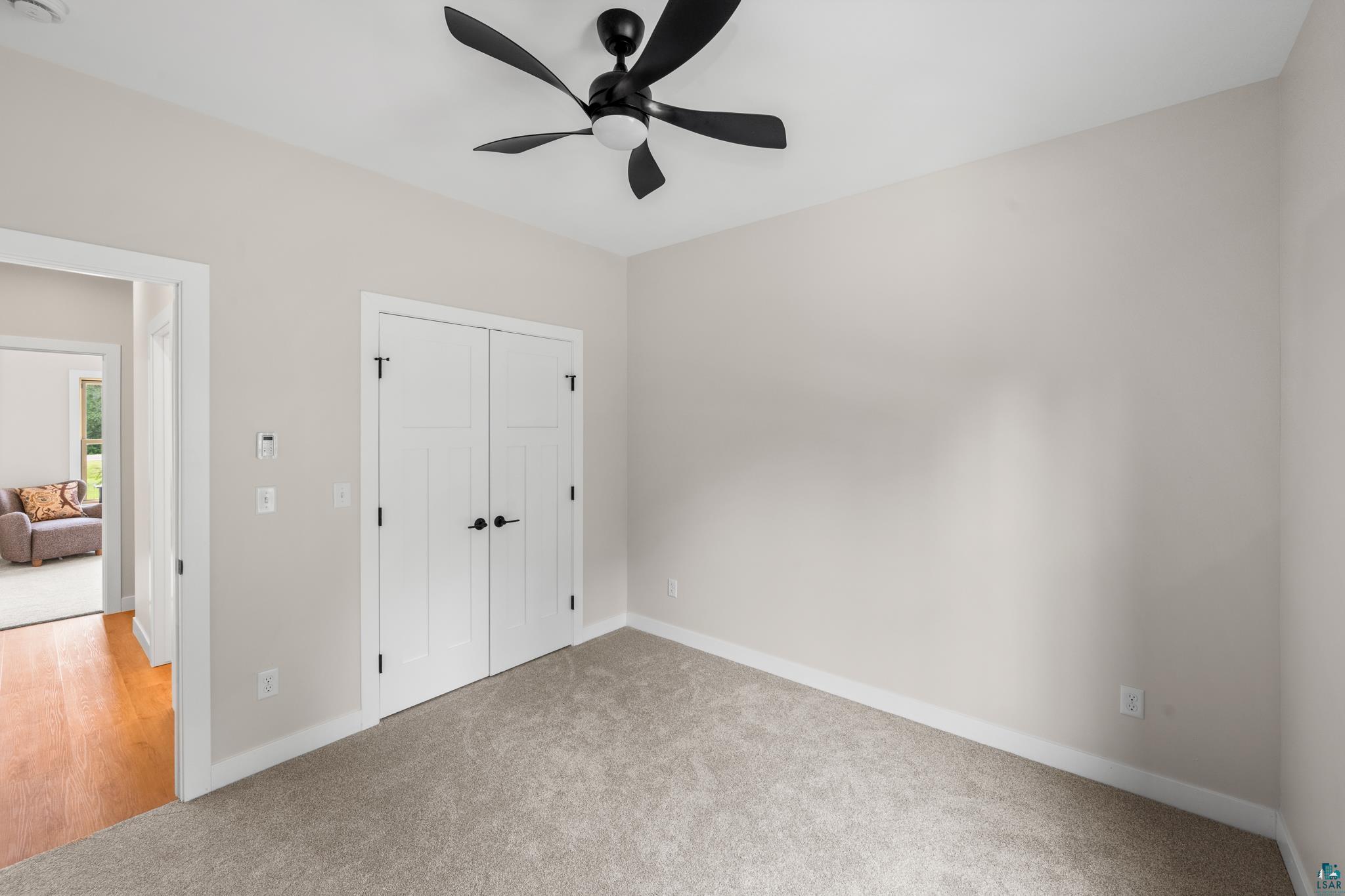 1241 Airport Road Two Harbors, MN 55616 - Photo 43 of 54 Neutral wall paint, ceiling fan, carpet flooring, and white bi-fold doors with black hardware