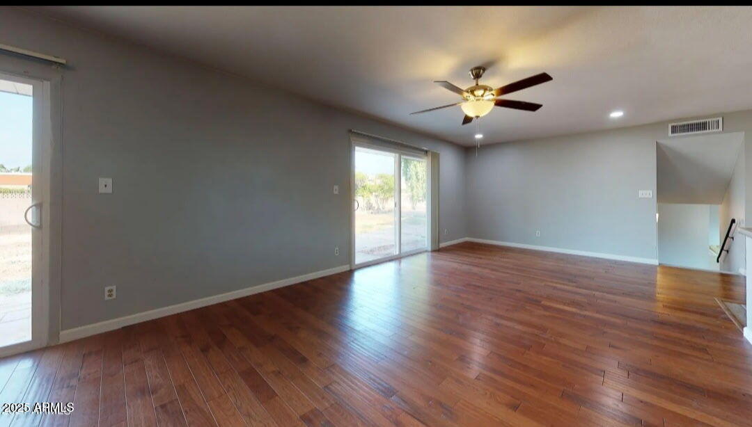 4216 West Solano Drive Phoenix, AZ 85019 - Photo 3 of 13 a view of an empty room with window and wooden floor