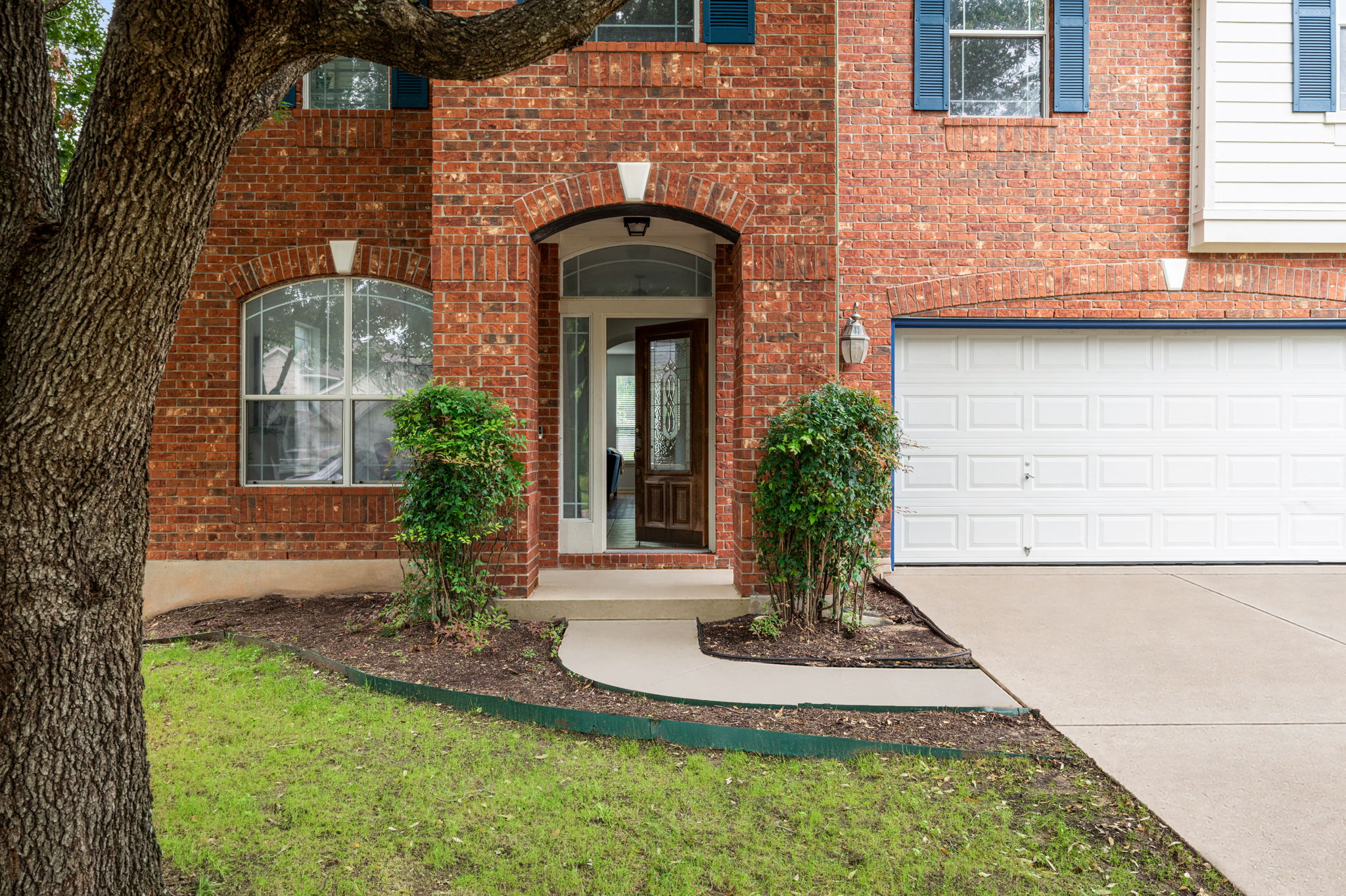10004 Isle Royale Way Austin, TX 78747 - Photo 3 of 31 A classic brick exterior offers enduring appeal, complemented by mature trees and manicured landscaping.