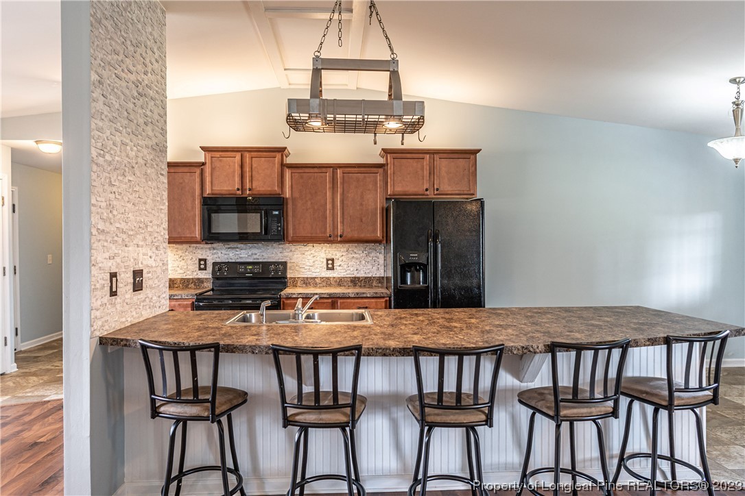20 Old English Lane Spring Lake, NC 28390 - Photo 11 of 41 a kitchen with stainless steel appliances granite countertop a stove top oven a sink a microwave and dining table