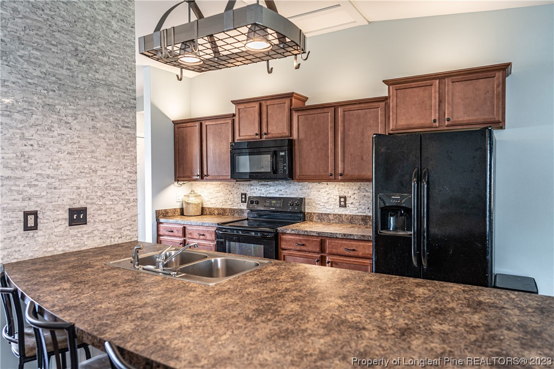 20 Old English Lane Spring Lake, NC 28390 - Photo 12 of 41 a kitchen with kitchen island granite countertop a stove cabinets and refrigerator