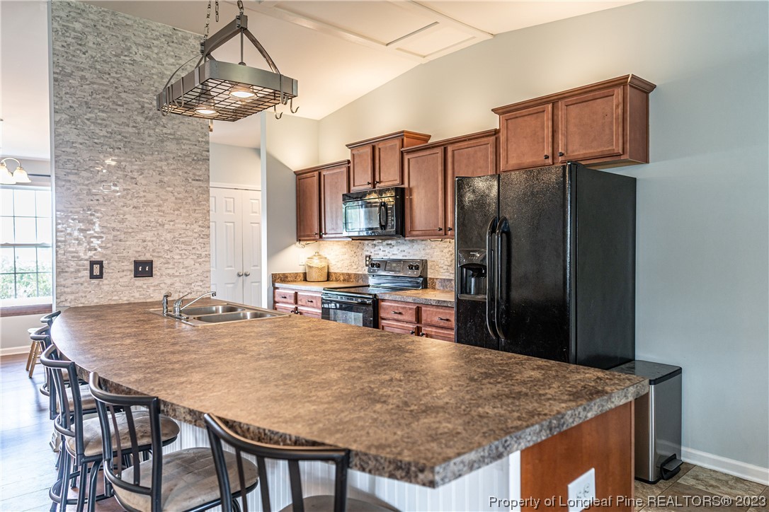 20 Old English Lane Spring Lake, NC 28390 - Photo 10 of 41 a kitchen with stainless steel appliances granite countertop a table chairs stove refrigerator and microwave