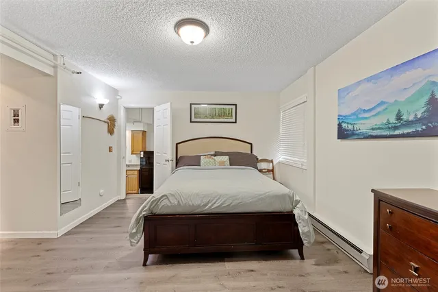 a spacious bedroom with a bed and a painting on the wall