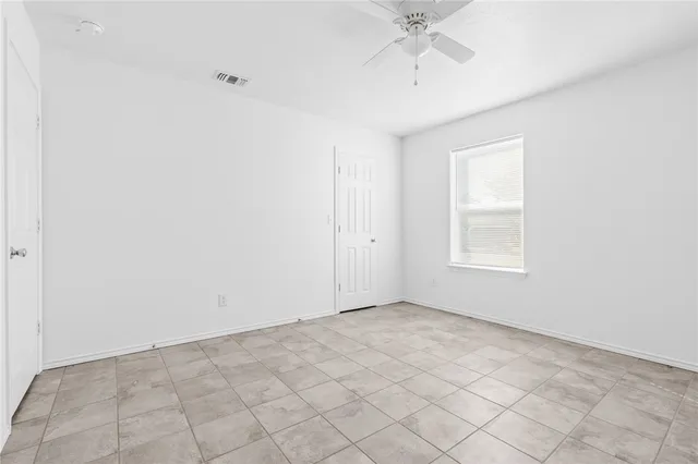 an empty room with a chandelier fan
