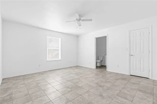 an empty room with fan and windows