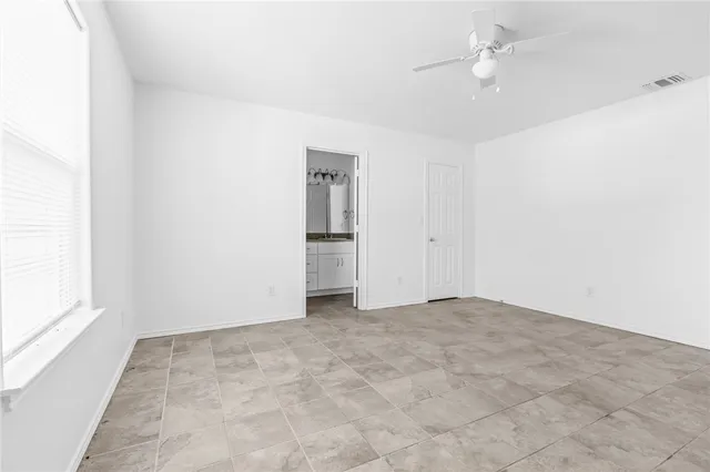 an empty room with a ceiling fan and a window