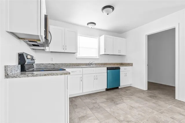 a kitchen with granite countertop a sink stainless steel appliances and cabinets