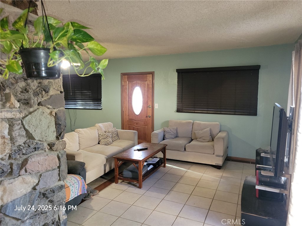27177 Cahuilla Road Apple Valley, CA 92307 - Photo 68 of 75 a living room with furniture a flat screen tv and a fireplace