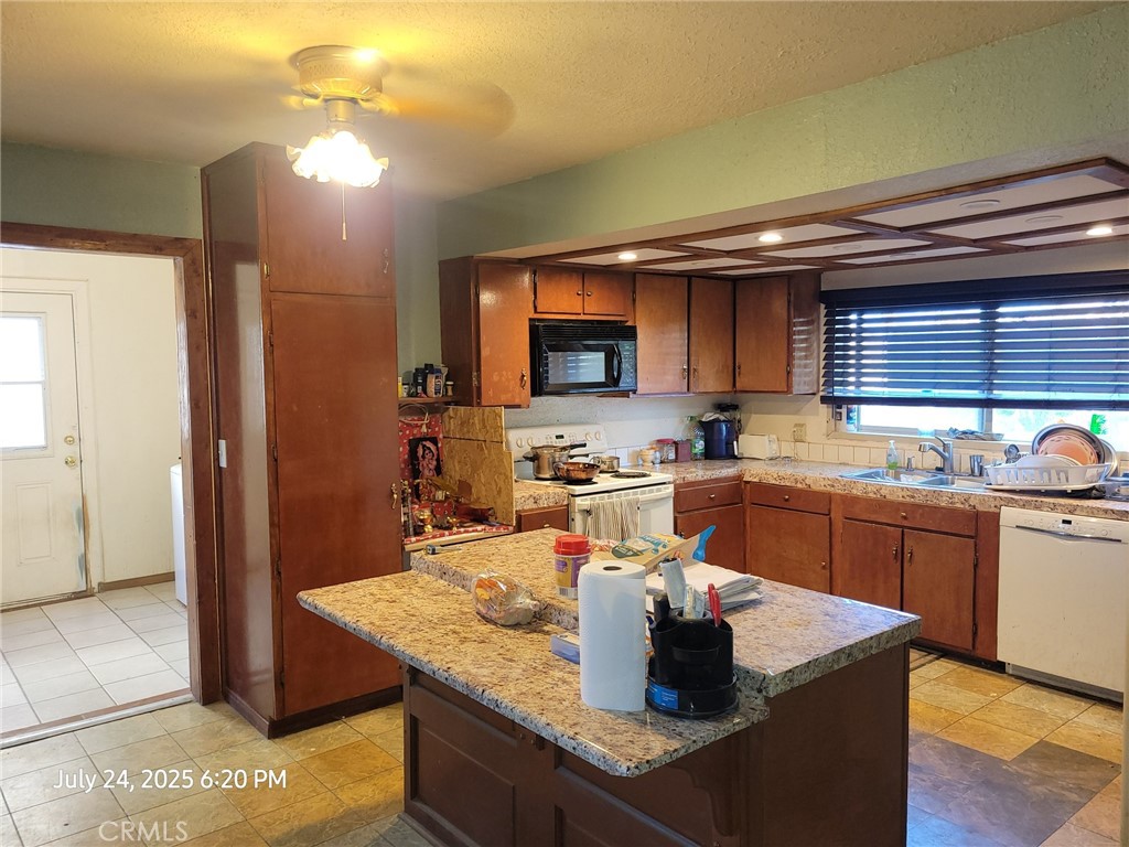 27177 Cahuilla Road Apple Valley, CA 92307 - Photo 75 of 75 a kitchen with stainless steel appliances granite countertop a sink dishwasher a stove and a refrigerator with wooden floor