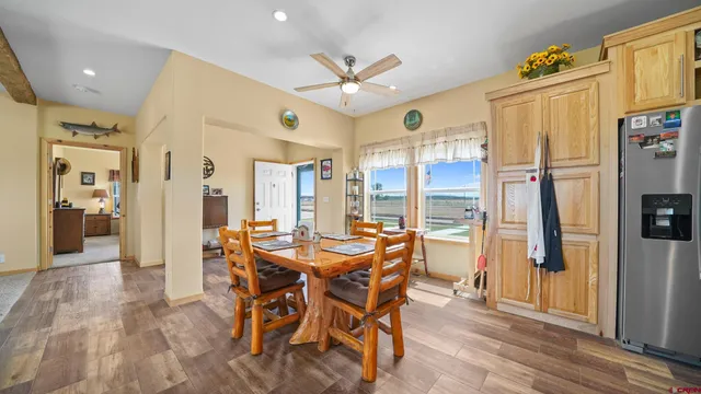 a dining room with stainless steel appliances a table chairs and chandelier