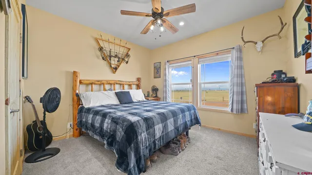 a bedroom with a bed a chandelier and dresser