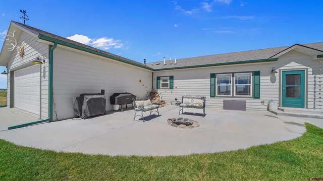 a view of the house with backyard and sitting area