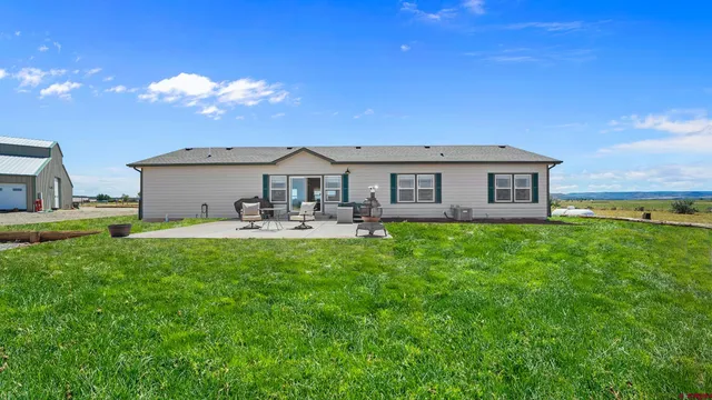 a front view of house with yard and outdoor seating