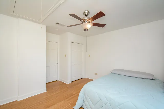 a bedroom with a bed and a chandelier fan