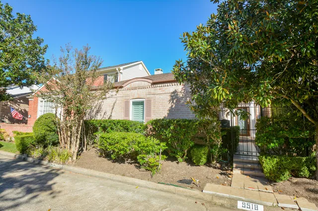 a front view of a house with a yard and tree s