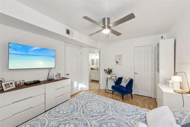 a spacious bedroom with a bed and a chandelier