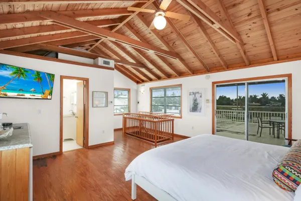 a bedroom with a bed and wooden floor