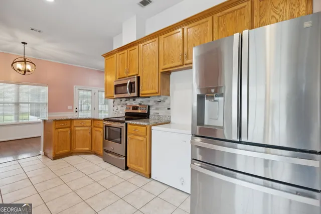 a kitchen with stainless steel appliances a refrigerator sink and microwave