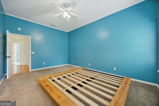 a view of a room with a ceiling fan and wooden floor
