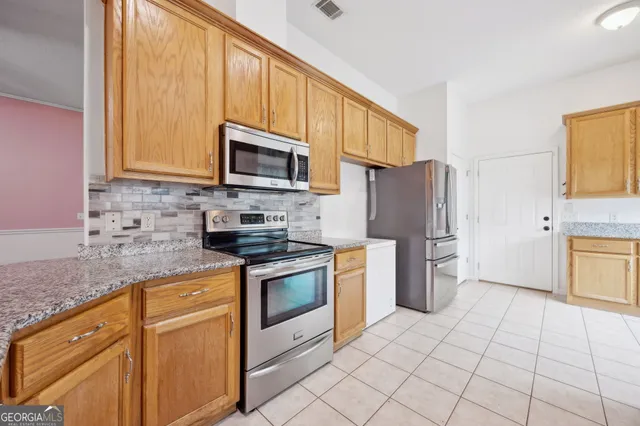 a kitchen with stainless steel appliances granite countertop a stove a sink and a microwave