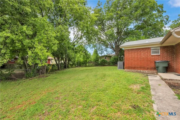 a view of backyard of house with green space