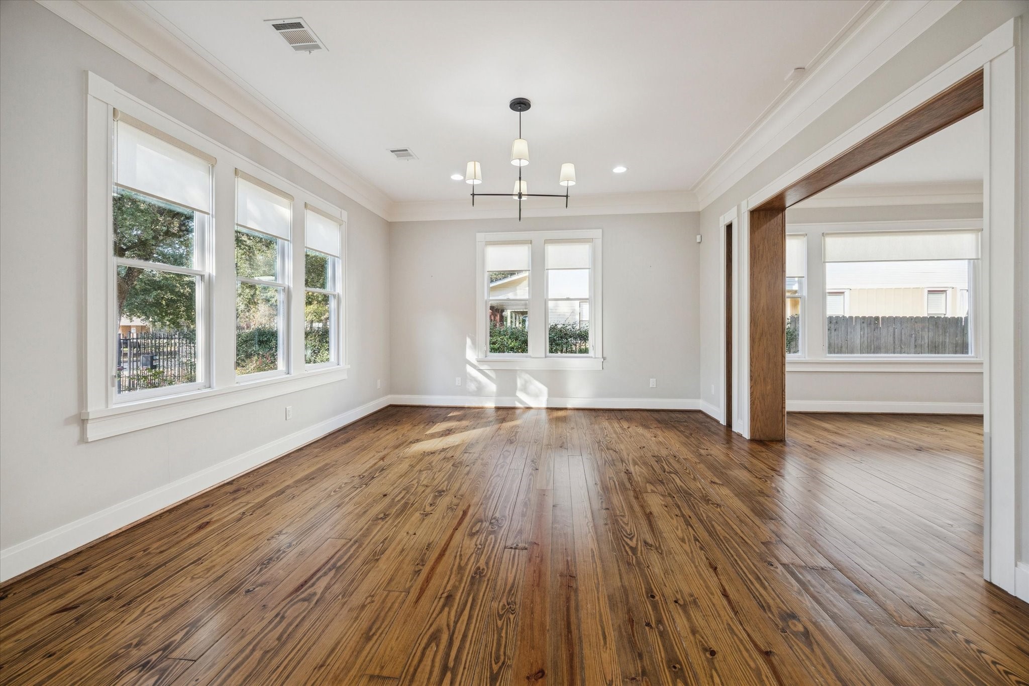 1226 Heights Boulevard Houston, TX 77008 - Photo 5 of 40 Spacious living room filled with natural light from multiple windows. Hardwood floors and crown molding create a warm yet refined atmosphere.