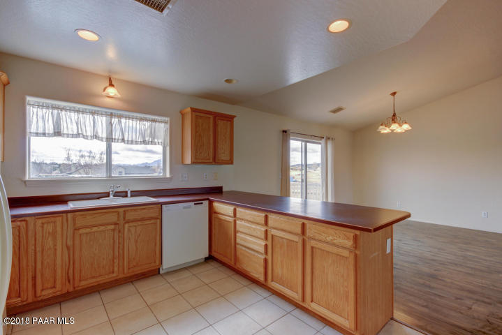 2165 West Lazy Ranch Road Chino Valley, AZ 86323 - Photo 6 of 17 a large kitchen with kitchen island granite countertop a sink and dishwasher wooden cabinets with a large window