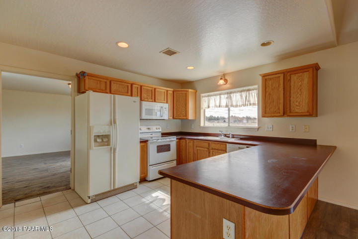 2165 West Lazy Ranch Road Chino Valley, AZ 86323 - Photo 7 of 17 a kitchen with stainless steel appliances granite countertop a sink a stove and a refrigerator