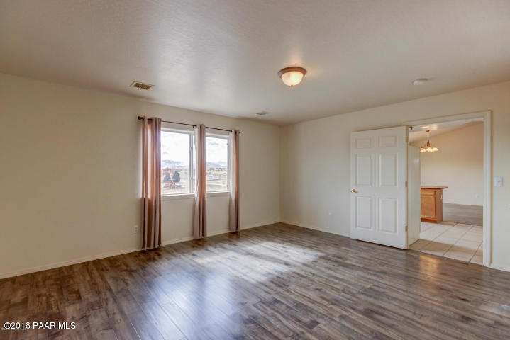 2165 West Lazy Ranch Road Chino Valley, AZ 86323 - Photo 8 of 17 an empty room with wooden floor and windows