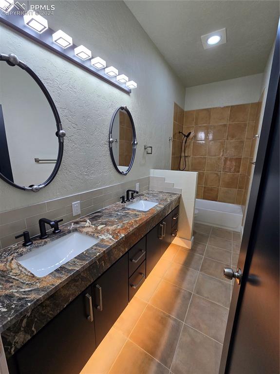 33036 Meadow Ridge Lane Trinidad, CO 81082 - Photo 28 of 50 Bathroom featuring tile patterned flooring, vanity, tiled shower / bath combo, and backsplash