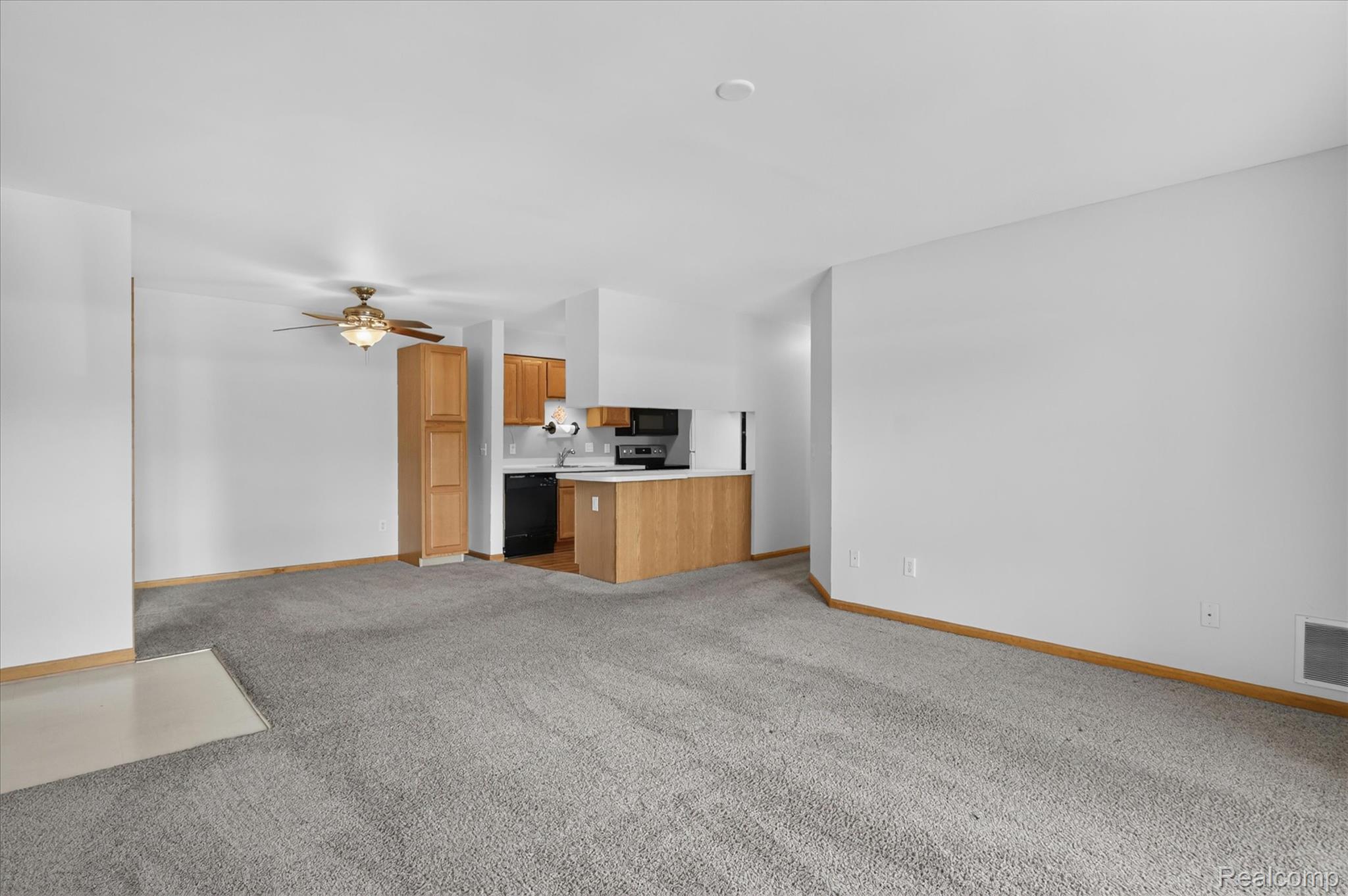 45720 Prairiegrass Court Belleville, MI 48111 - Photo 7 of 31 Open concept living area featuring light-toned carpet flooring and a ceiling fan