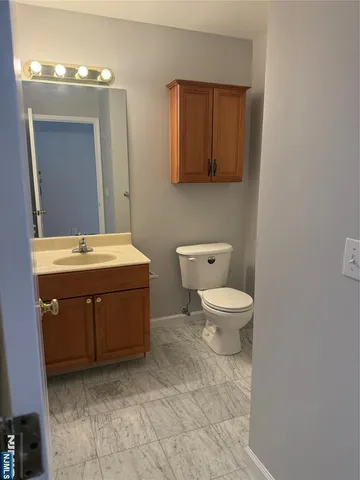 a spacious bathroom with a toilet sink and mirror