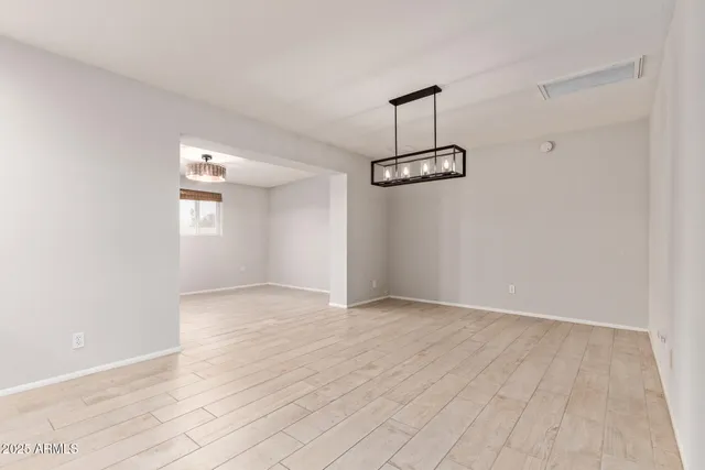 a view of empty room with wooden floor and ceiling fan