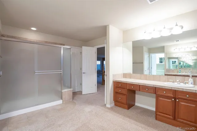 a spacious bathroom with a tub sink and mirror