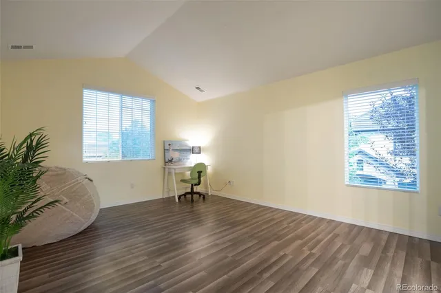 a view of a room with wooden floor and a window