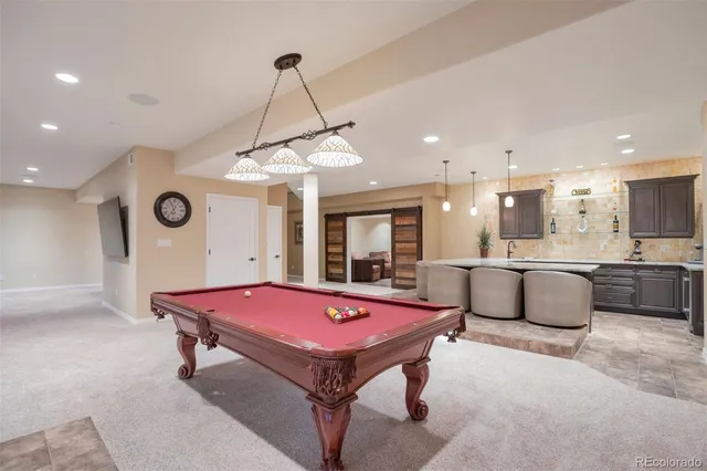 a room with pool table and windows