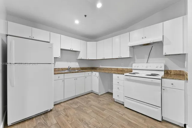 a kitchen with cabinets appliances a sink and a counter space