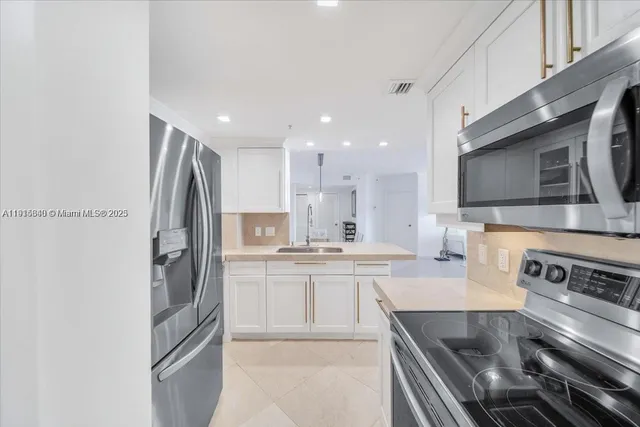 a kitchen with stainless steel appliances granite countertop a refrigerator stove and sink