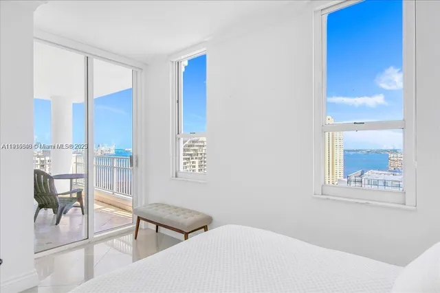 a bedroom with furniture and three windows