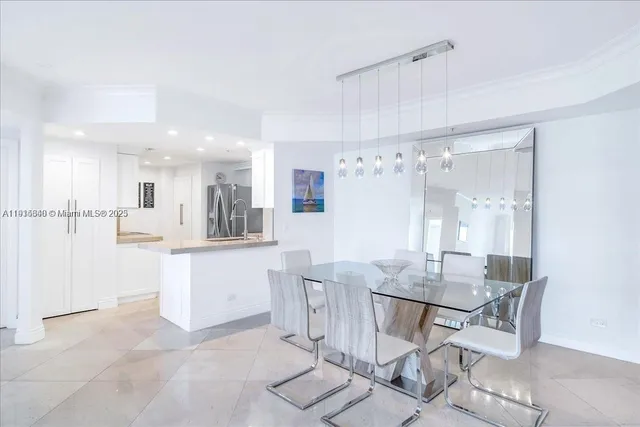 a kitchen with kitchen island a dining table chairs cabinets and stainless steel appliances