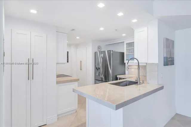 a kitchen with kitchen island a sink appliances and cabinets