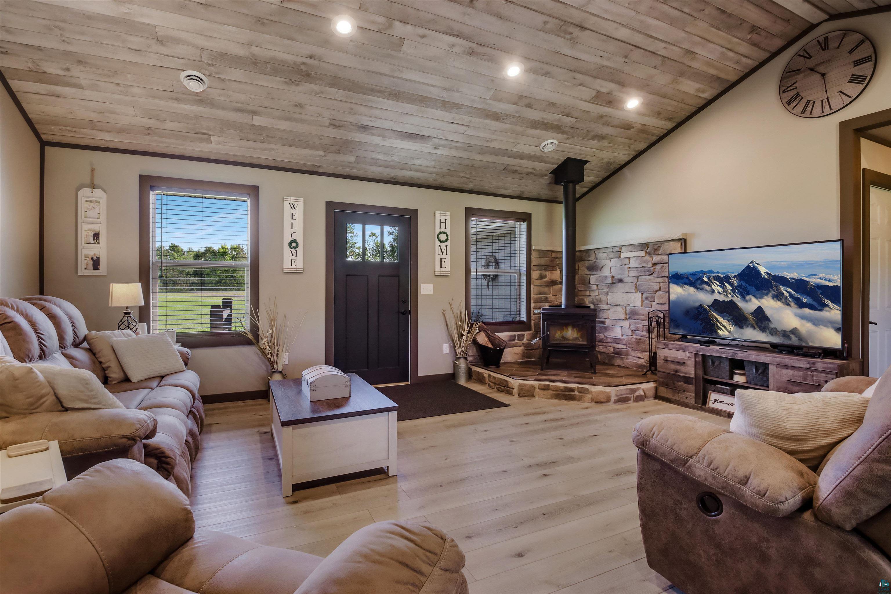 N3685 Fenander Road Spooner, WI 54801 - Photo 14 of 38 Living room featuring a wood stove, light hardwood / wood-style floors, lofted ceiling, and wood ceiling