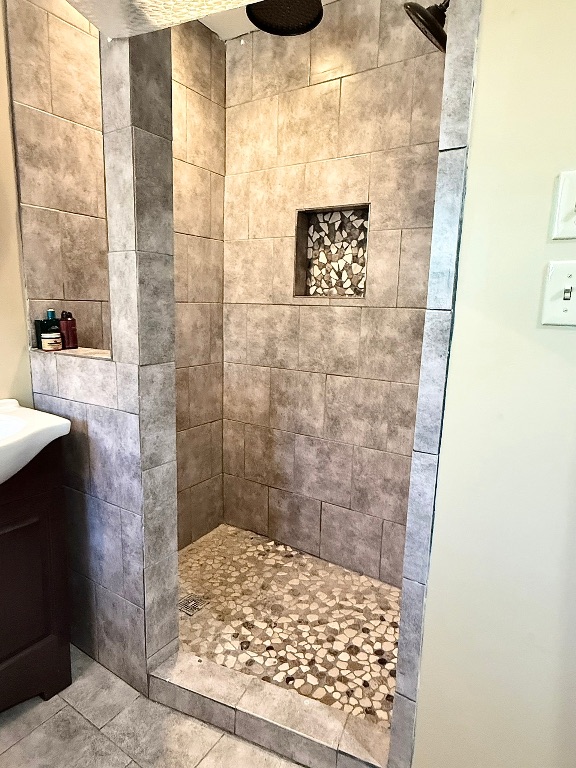 211 Rabbit Hollow Lane Georgetown, TX 78626 - Photo 17 of 32 Bathroom featuring tiled shower, vanity, and tile patterned floors