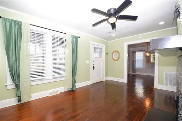 a view of an empty room with window and wooden floor