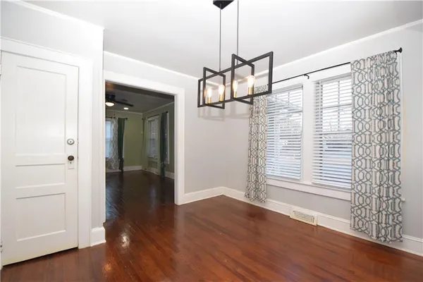 a view of a hallway with wooden floor and windows