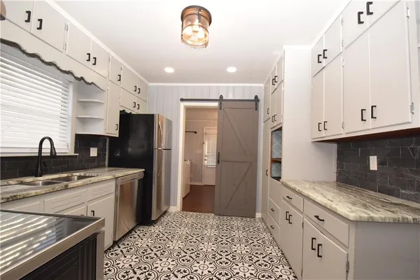 a kitchen with stainless steel appliances granite countertop a refrigerator and a stove top oven