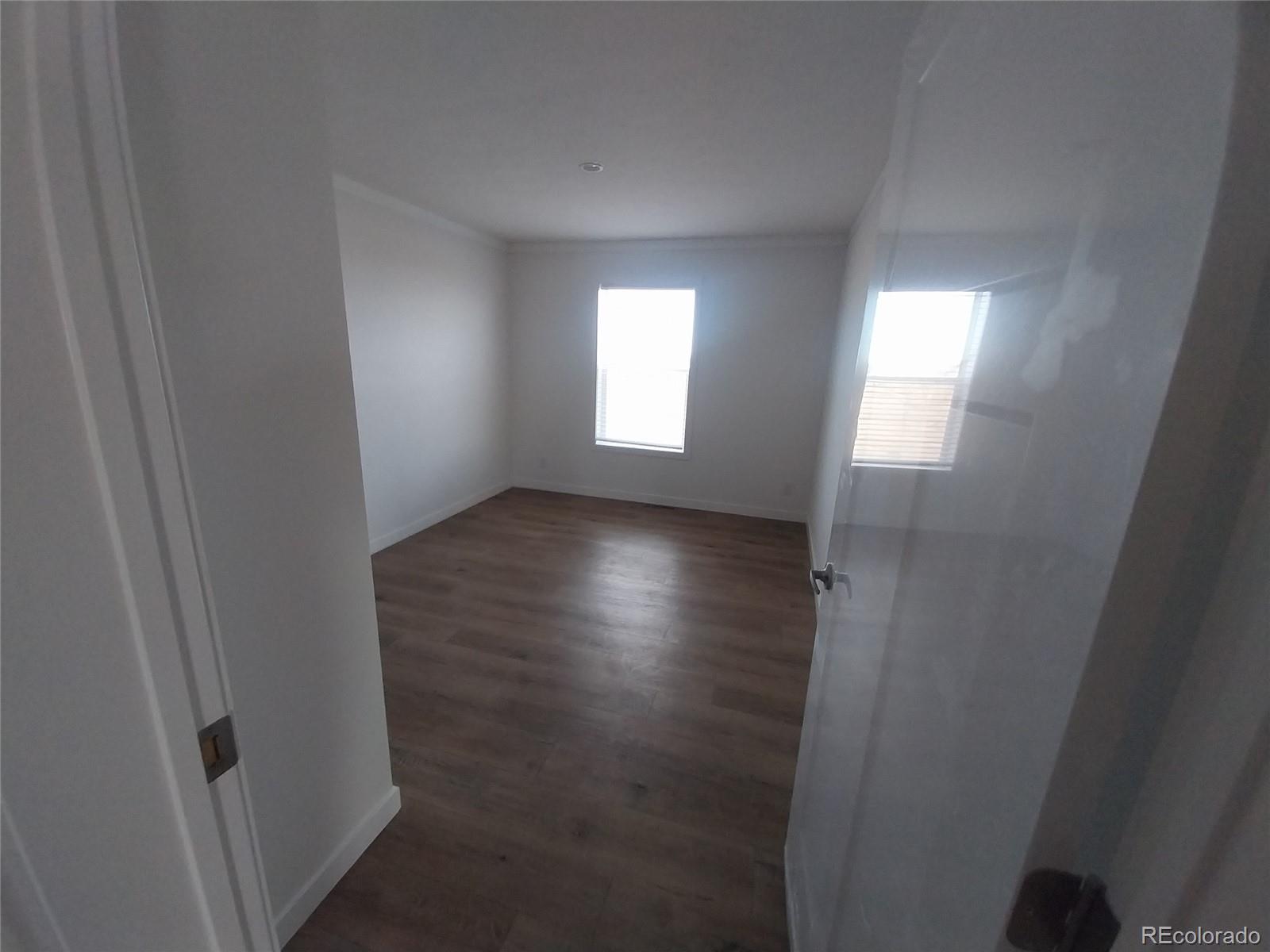 898 North Ramah Highway Yoder, CO 80864 - Photo 16 of 18 an empty room with wooden floor and windows