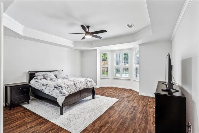 a spacious bedroom with a bed and a flat screen tv