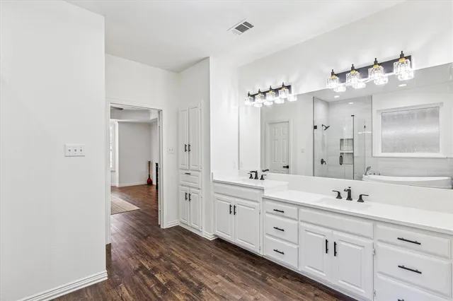 a spacious bathroom with a double vanity sink and a mirror