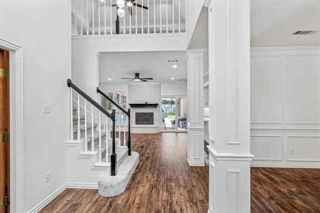 a view of a hallway with wooden floor and staircase
